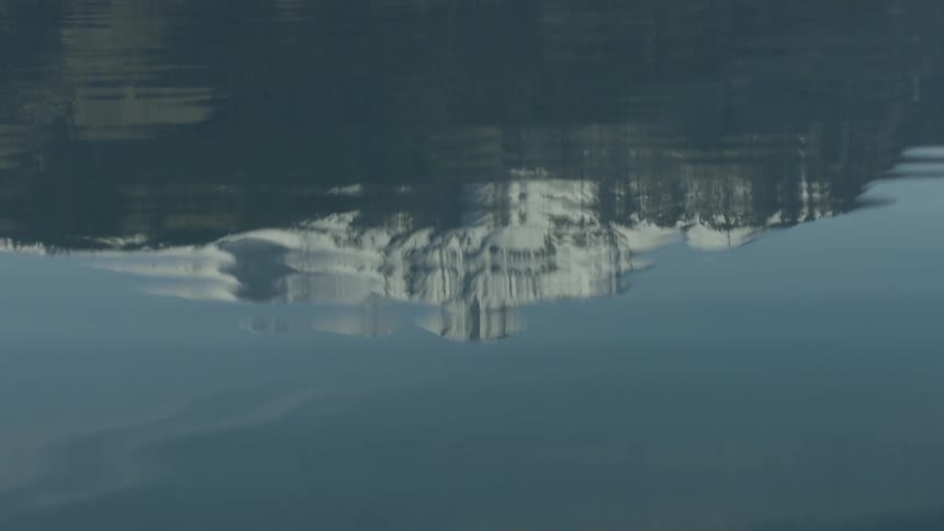 Water reflects a snowy mountain