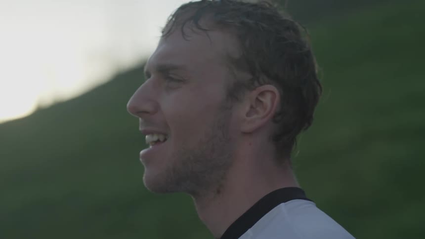 A man is standing outside smiling