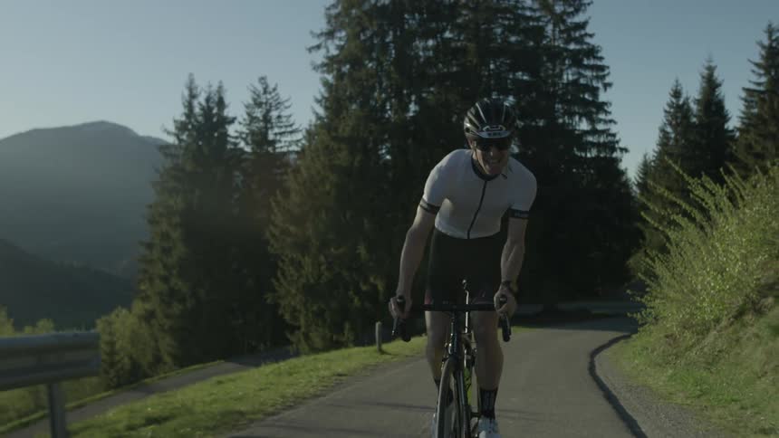 A man bicycles on a mountain road