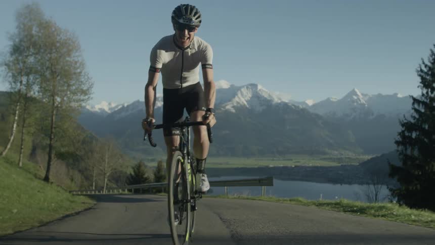 A man bicycles on a mountain road