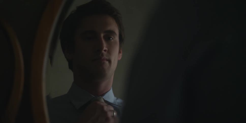 Man adjusting his tie in the mirror