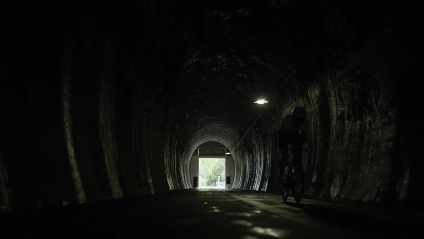 A man rides into the dark tunnel