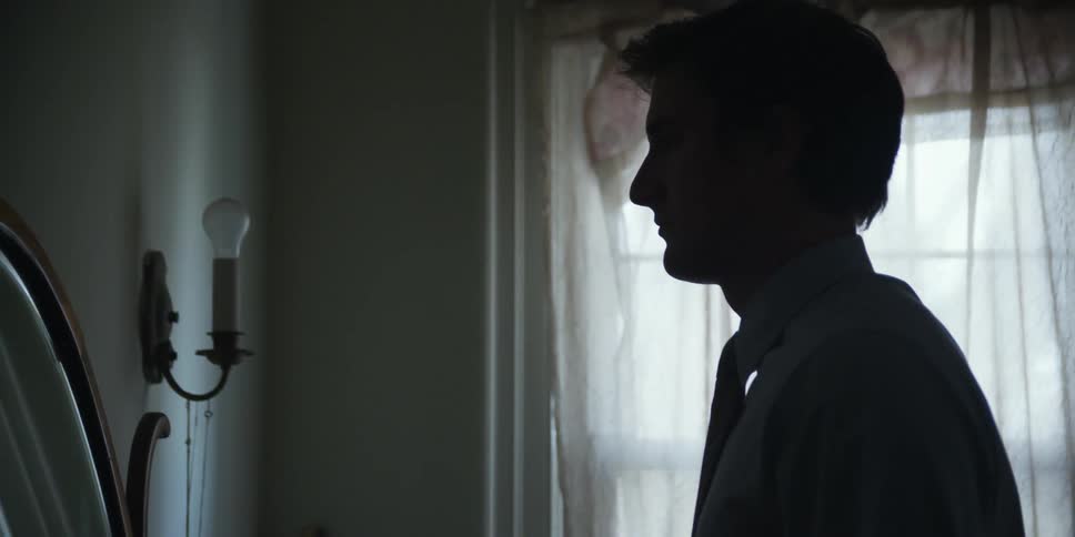 A man is standing near a wall