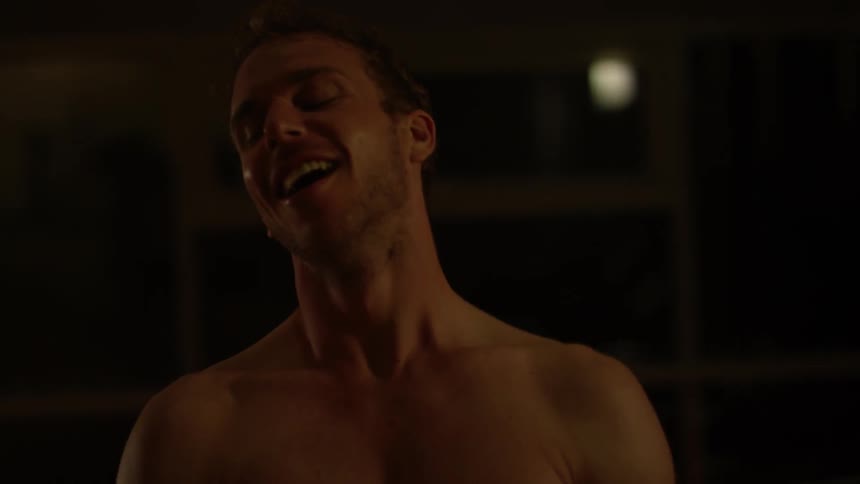 A man smiles as he stands up from a workout