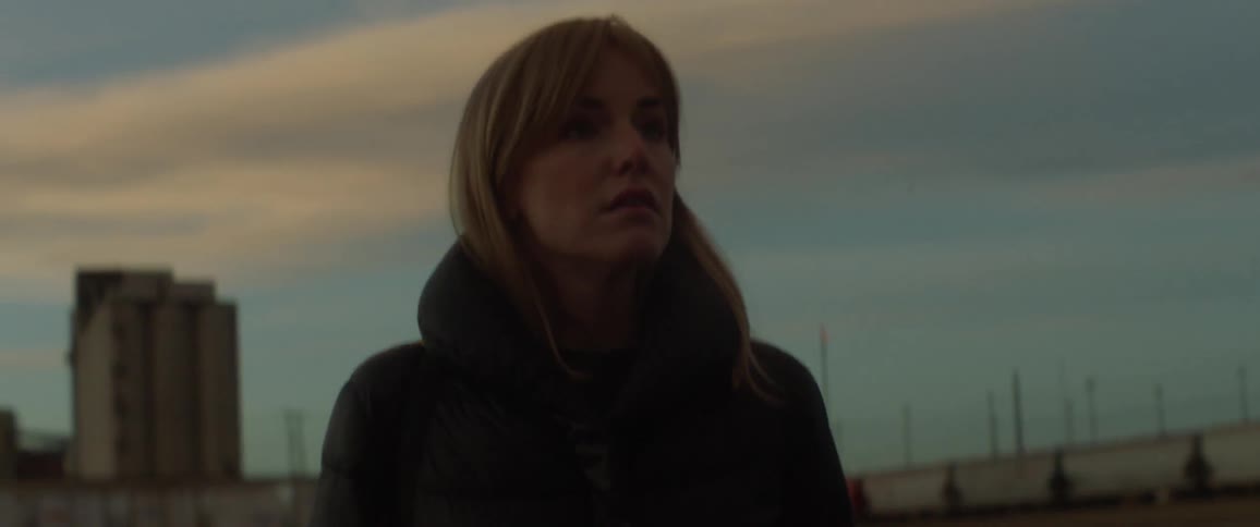 A woman looks around at sunset in the lot
