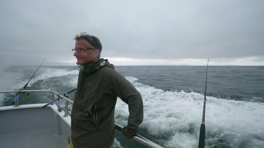 A man fishes from a boat on the ocean