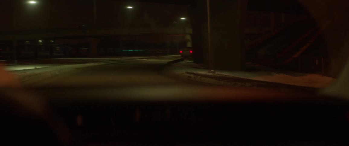 A car pulls around a truck with its blinkers on at night