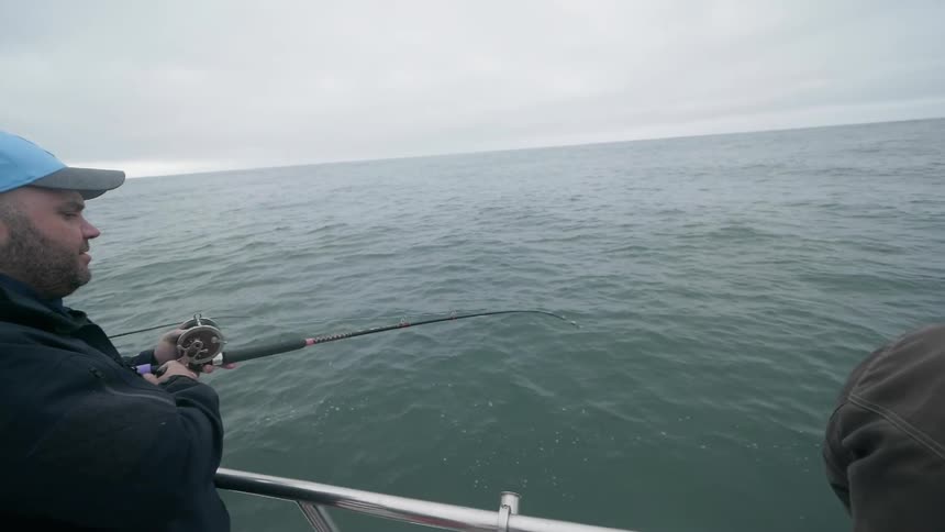 Men fish on a boat at sea