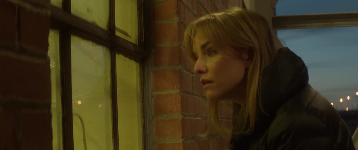 A woman looks inside a window