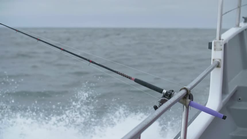 Waves crash into the side of a fishing boat