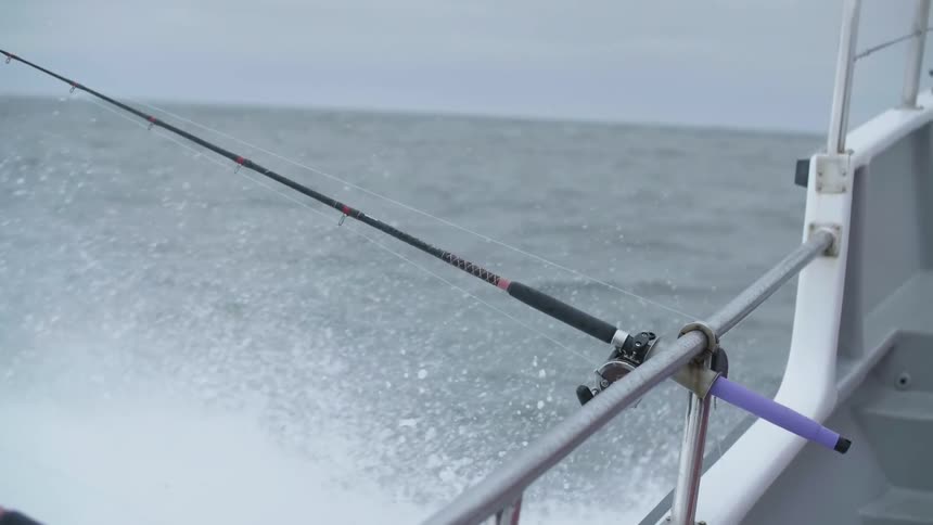 Waves crash onto the side of a fishing boat