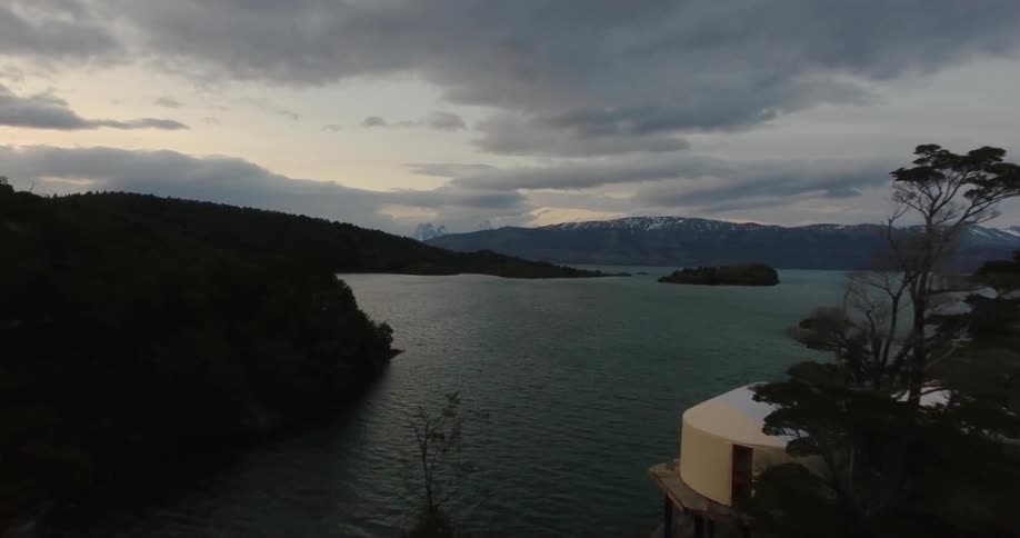 Clouds float above a mountain lake at sunset