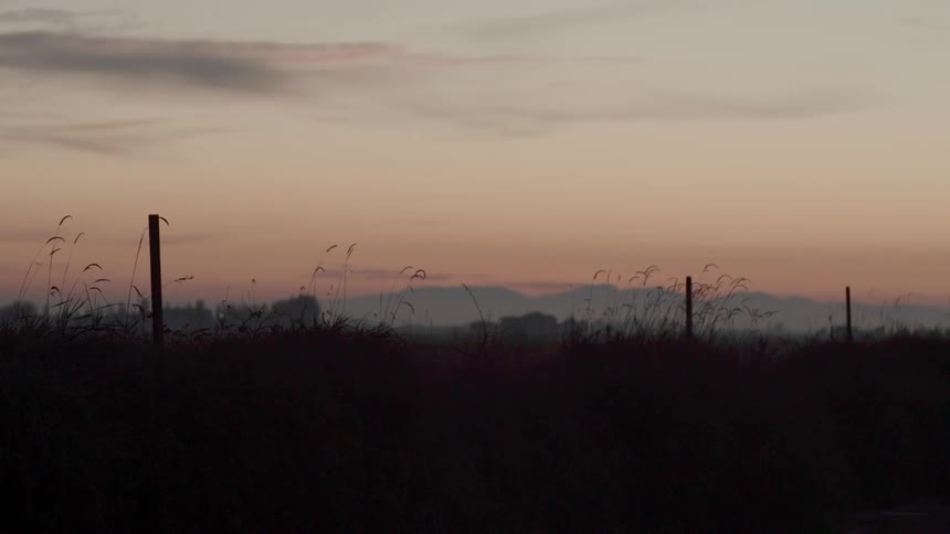 A light flashes on the horizon at sunset