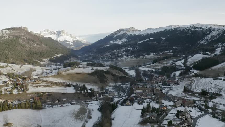 The town is covered in snow by the mountain