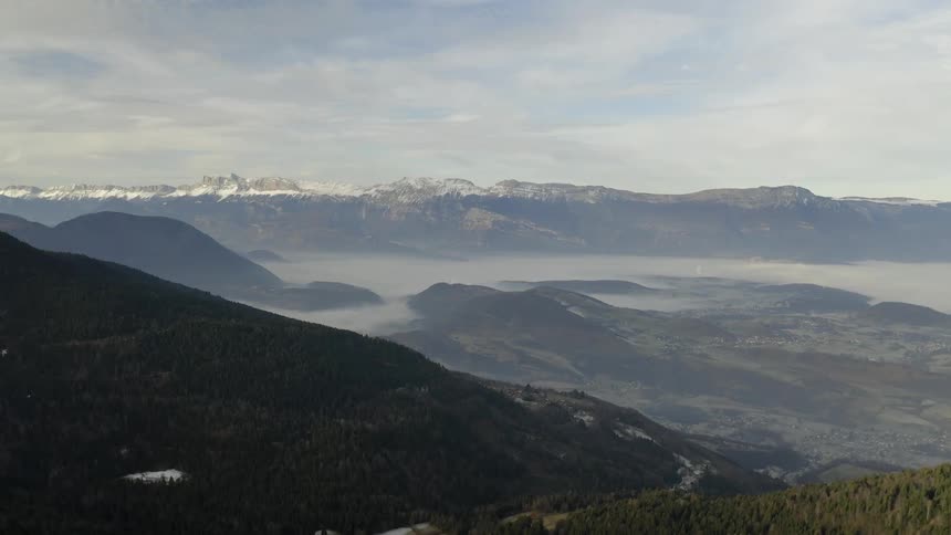 Fog rolls low over large mountains
