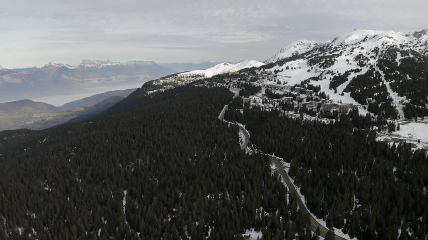 A road runs up the side of a snowy mountain