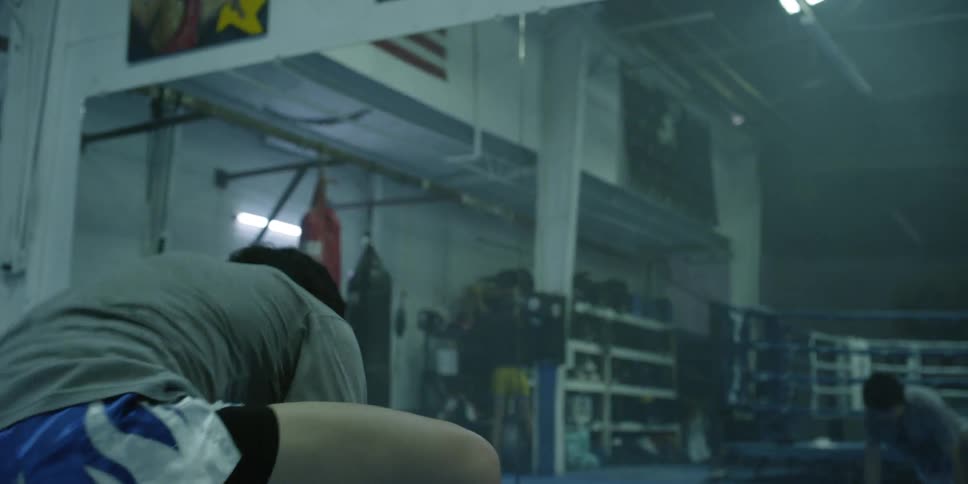 A man stretches next to a boxing ring