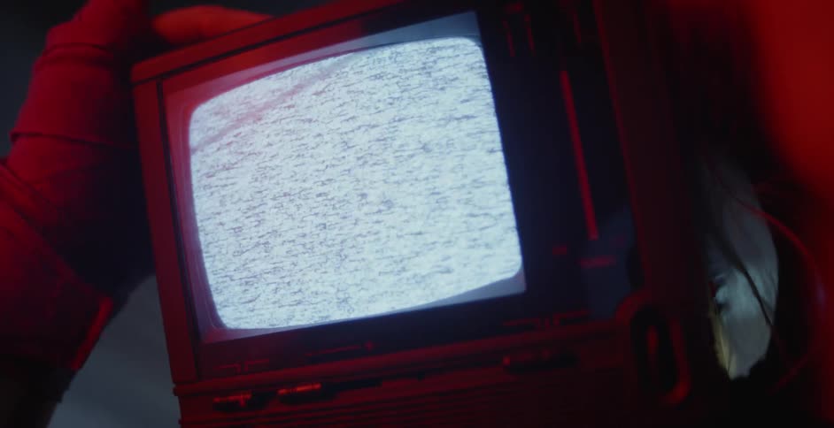 The television is flickering in the dark room