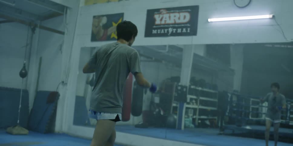 A man kicks the air in a gym