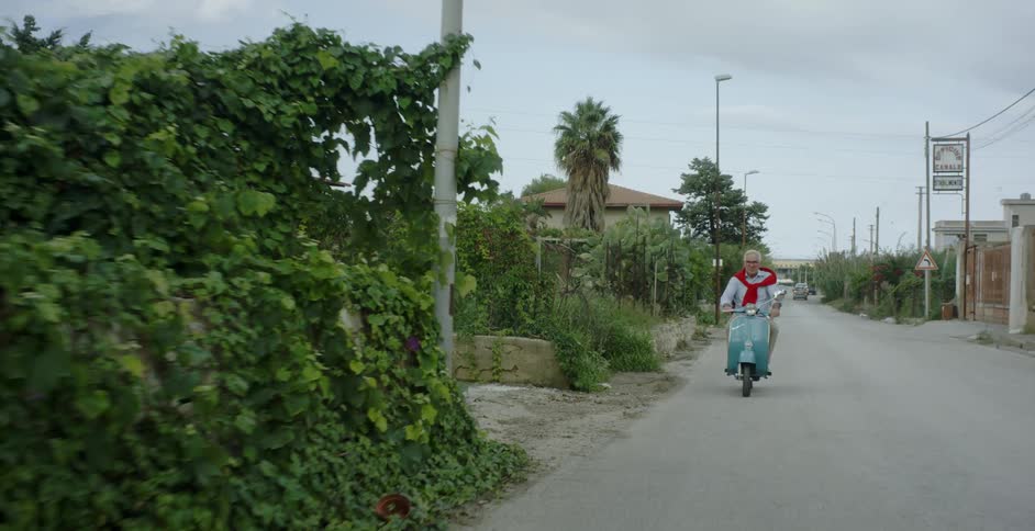 A man rides a scooter in a town