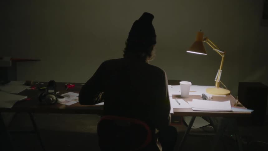 A man writes at a desk