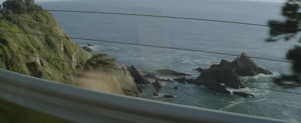 A car drives on a coastal road
