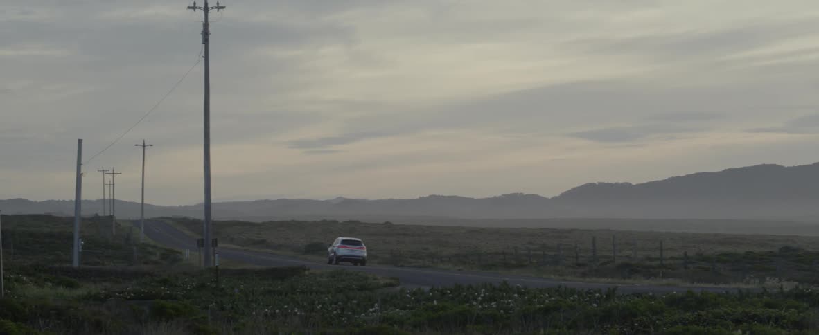 A car drives on a rural road
