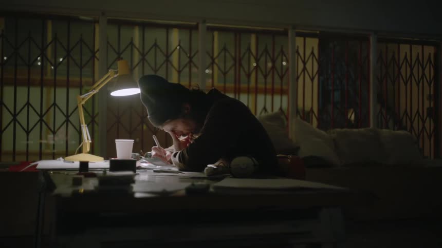 A man writes at a desk