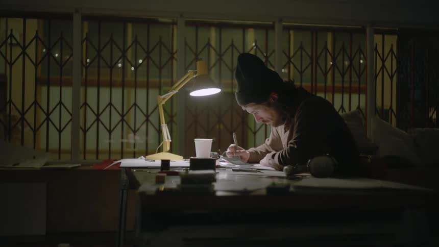 A man writes at a desk