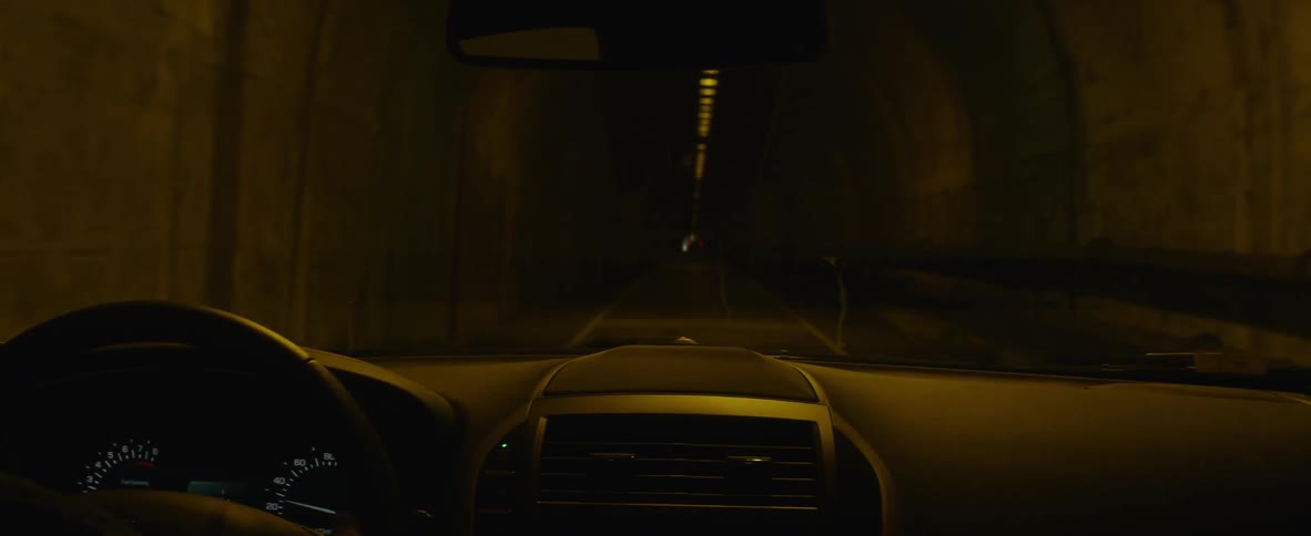 Car drives through a dark tunnel