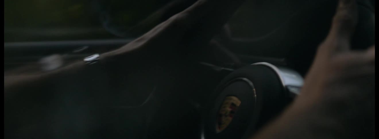 A man holds onto a car steering wheel