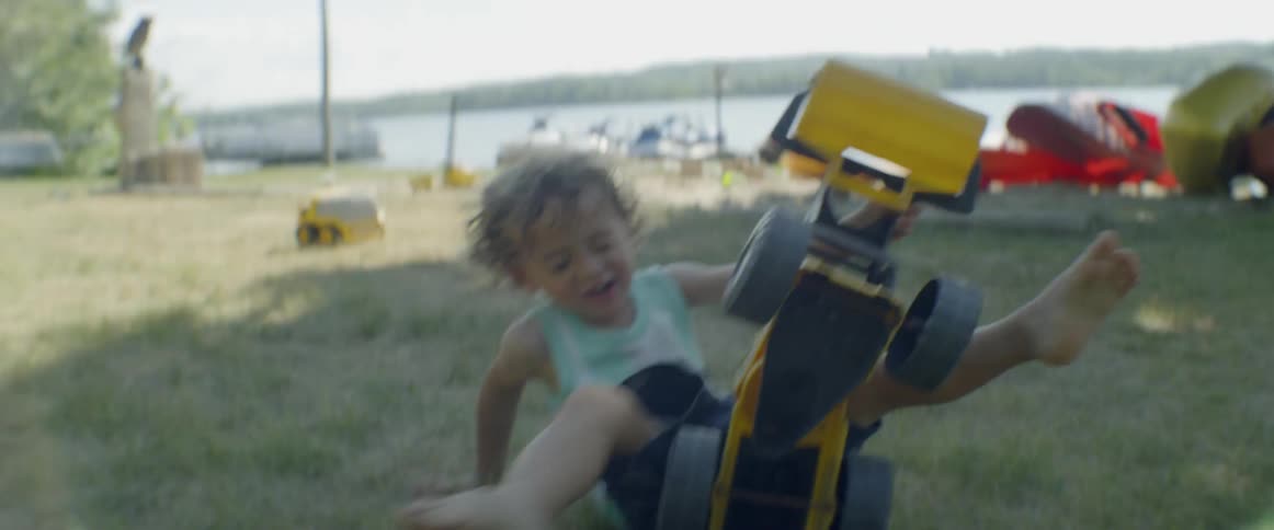 Child plays with a toy truck near a river
