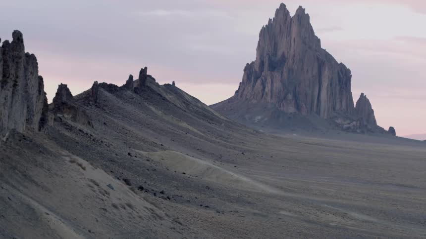 The sun sets behind rock formations in the desert