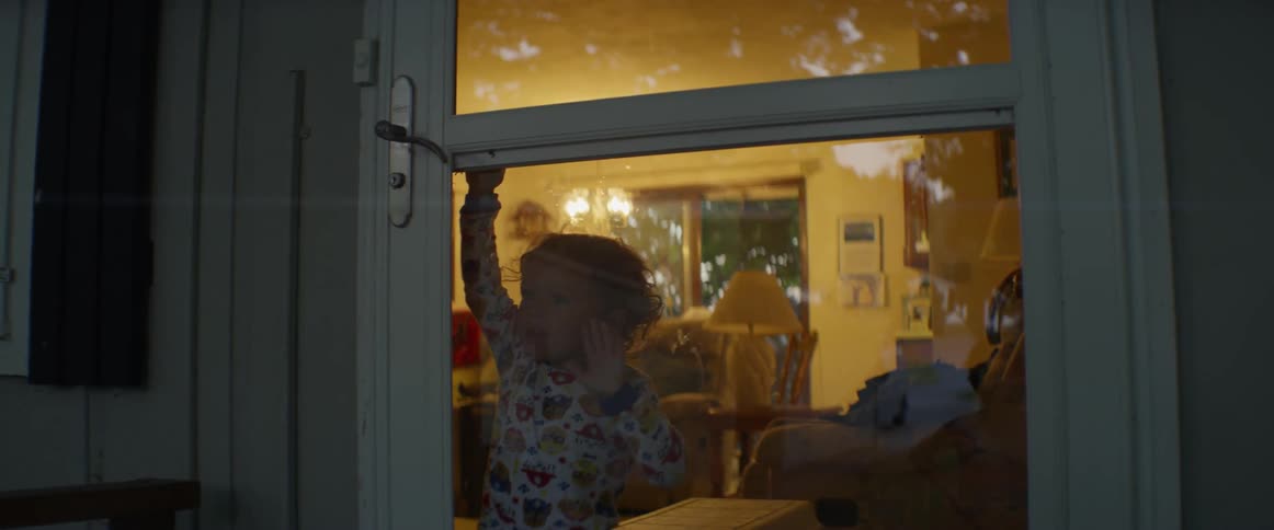 Small child tries to open glass door
