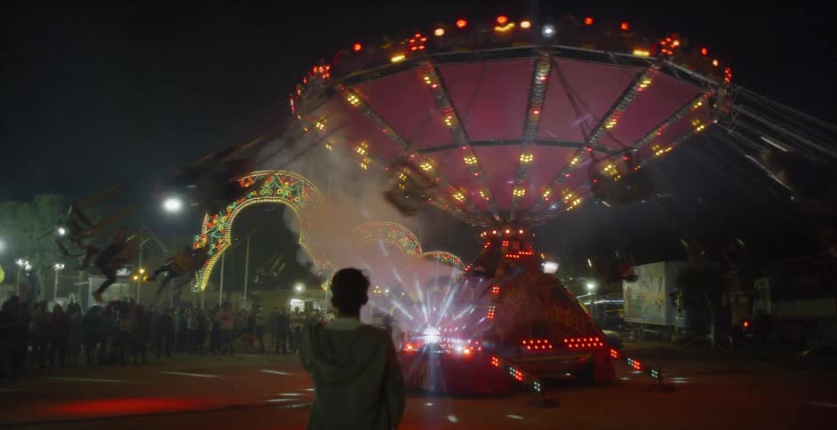 People ride an attraction at a carnival
