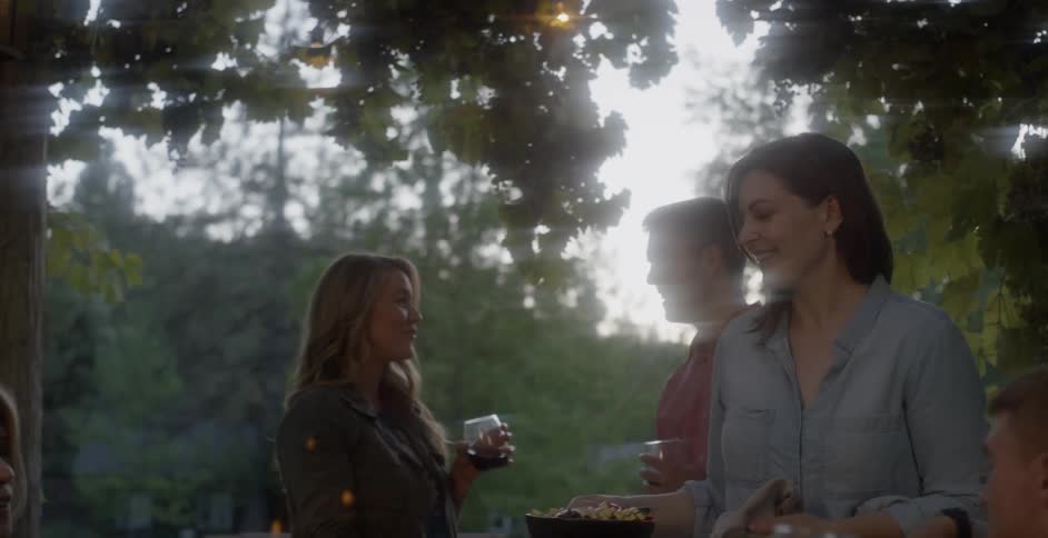 A group of people dine outside under the trees