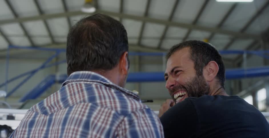 Two men talk and laugh