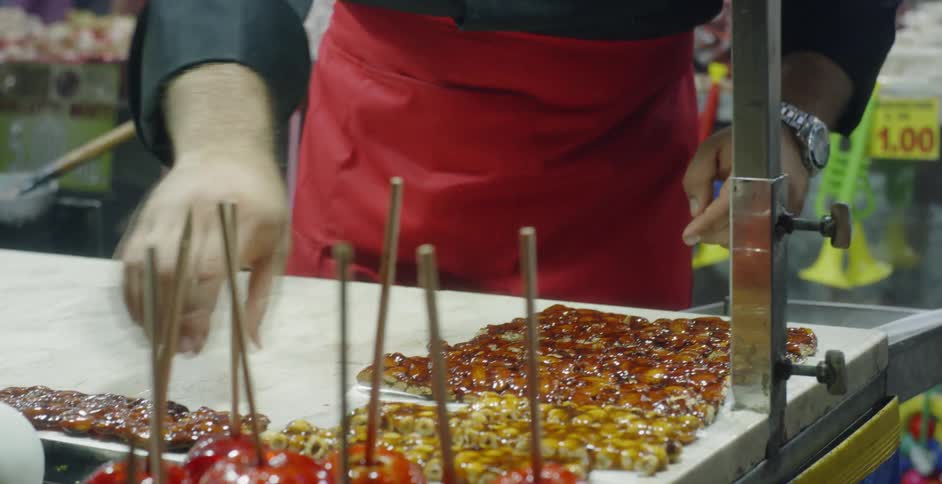 A man prepares sweets at a vendor stand