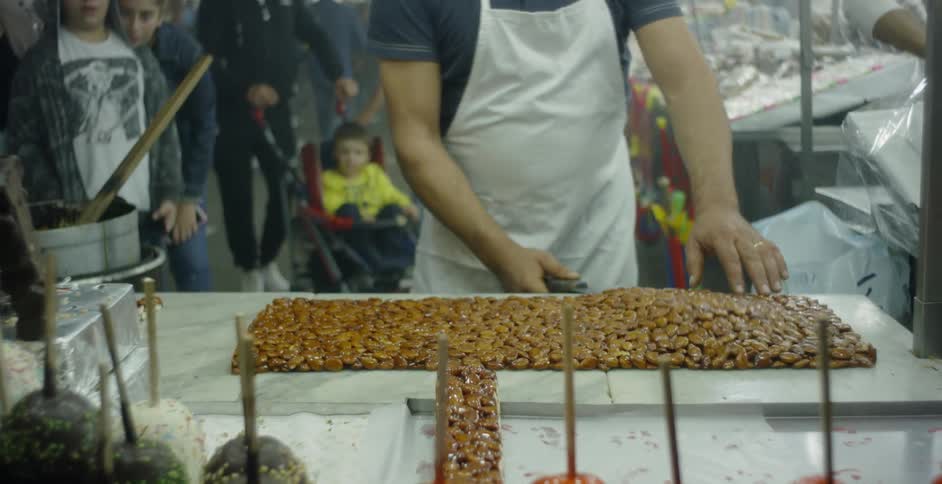 A man uses a large scraper to prepare food