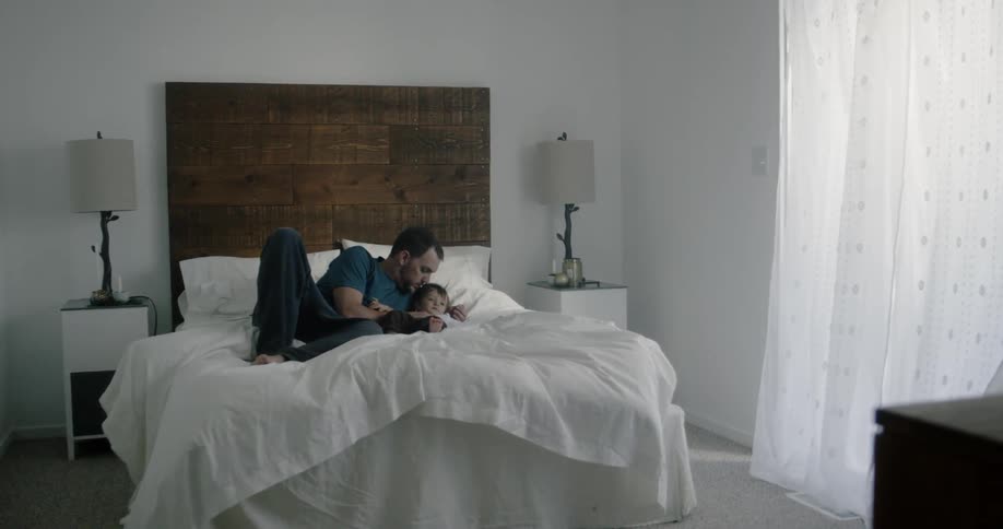 Man lies with baby in bed