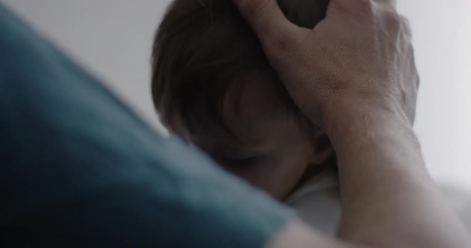 A hat is put on a child in a dark room