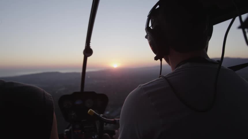 Person in helicopter at sunset
