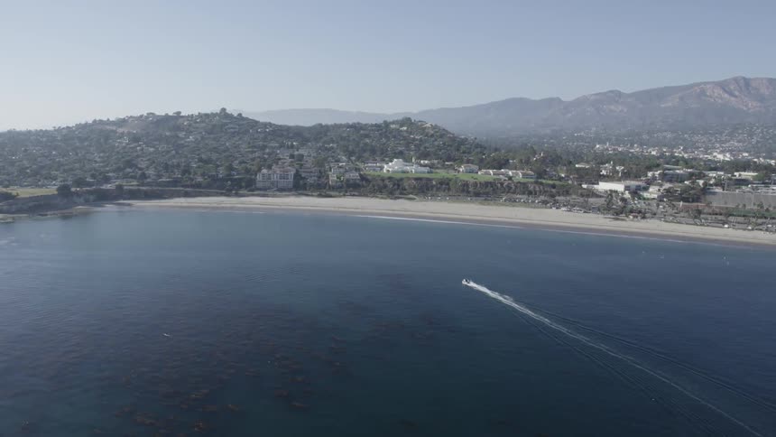 A Boat drives toward a beach in a city
