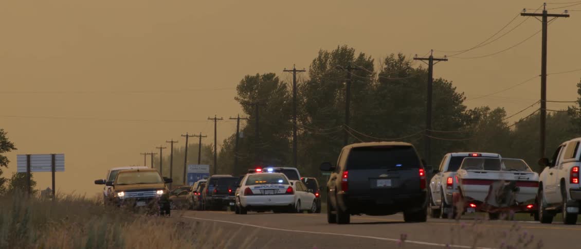 The law enforcement vehicles travel forward in the stopped traffic