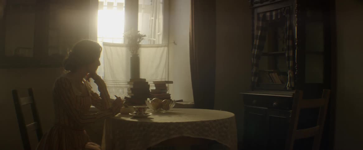 A woman sits at a small round table