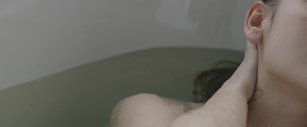 Woman lays in a tub of water