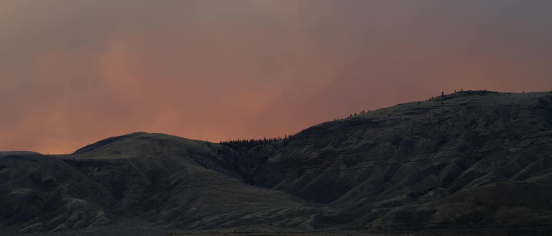 Clouds float over a mountain at sunset