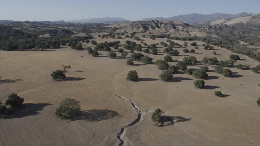 Aerial view of a large field with mountains in the distance
