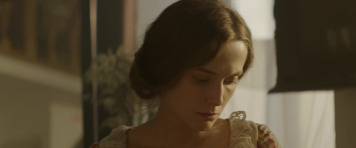 A woman is looking down in the room