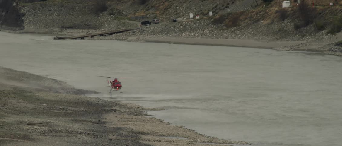 Helicopter flies low over a river of water